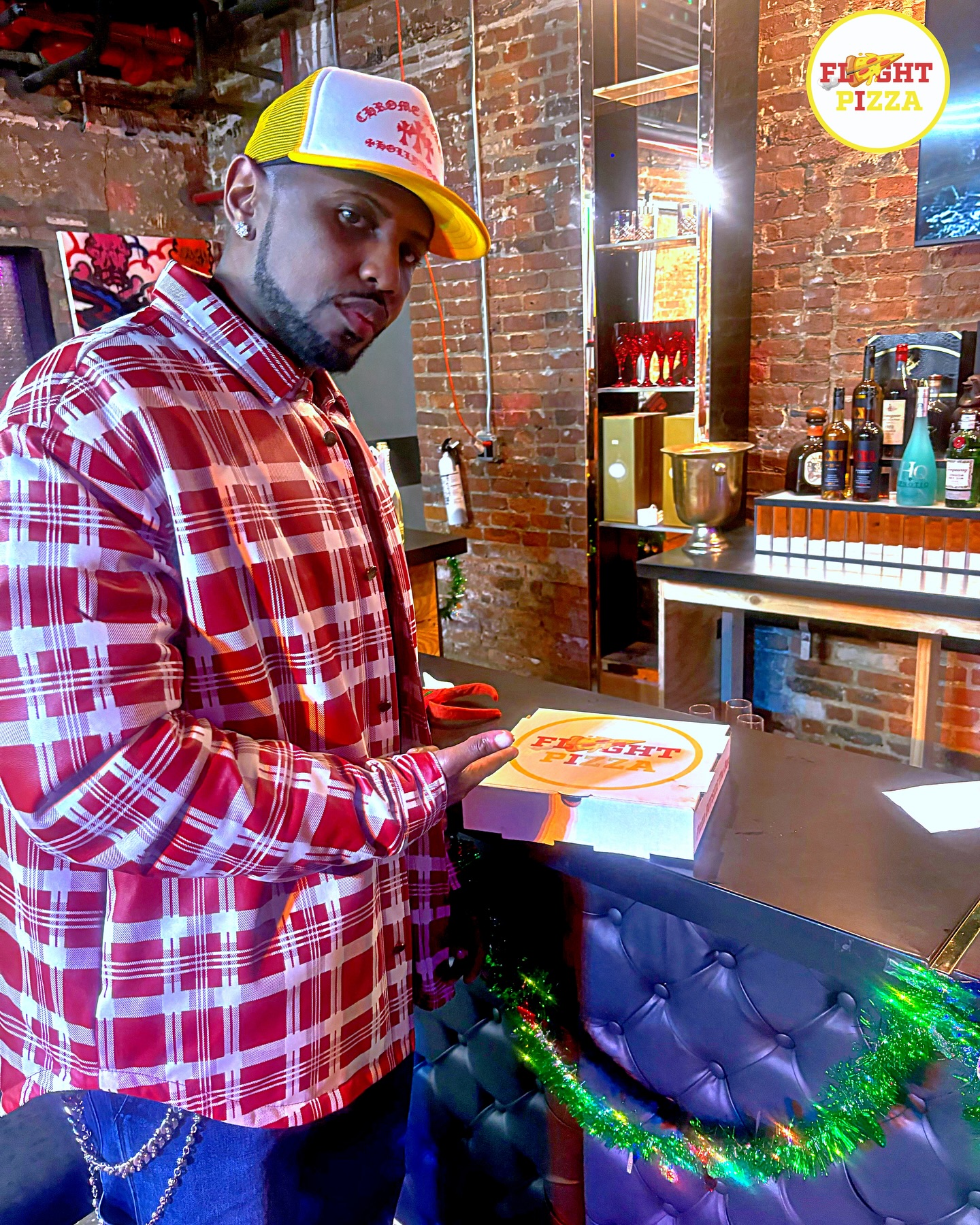 Guest with a fresh Flyght Pizza box at the bar