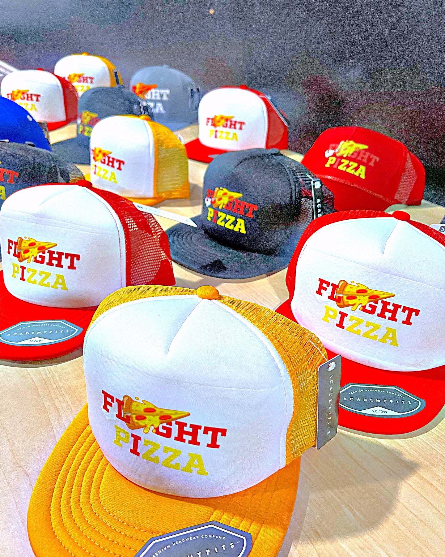 Flyght Pizza trucker hats on the merch table